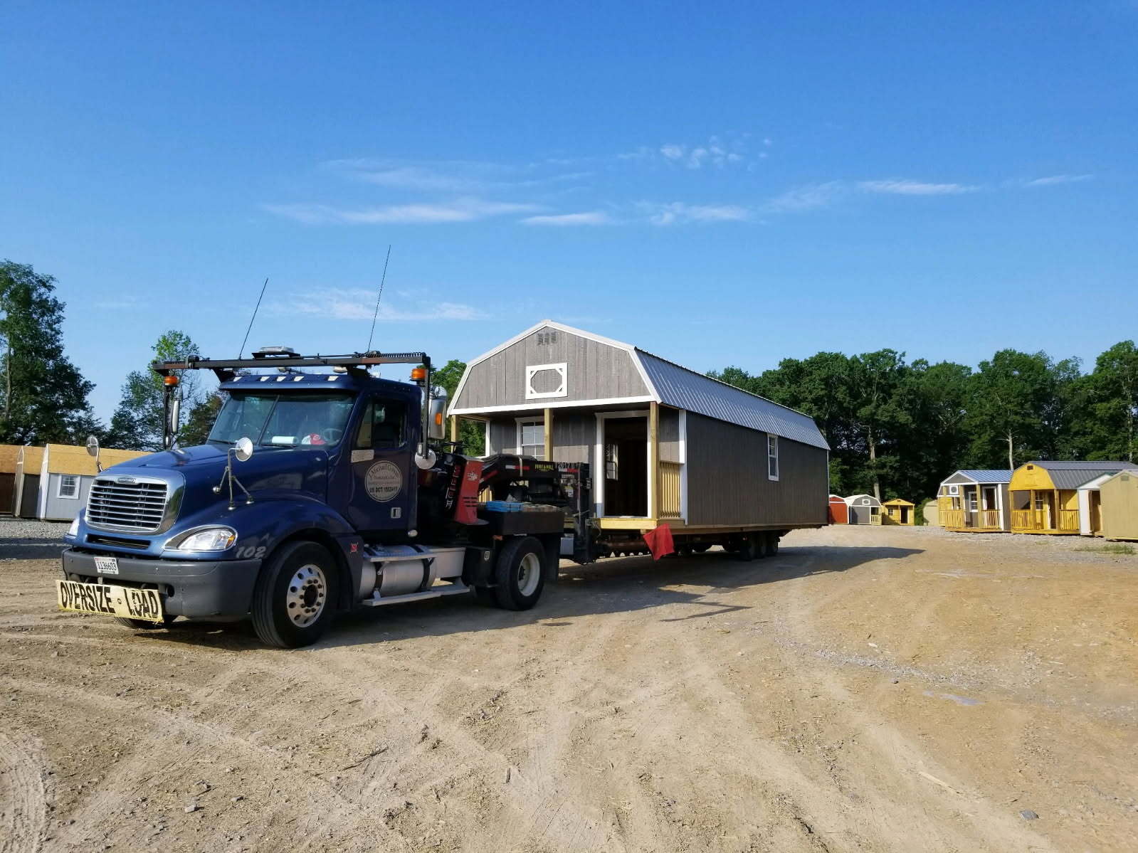 Prairie Built Barns delivery truck carrying a storage building